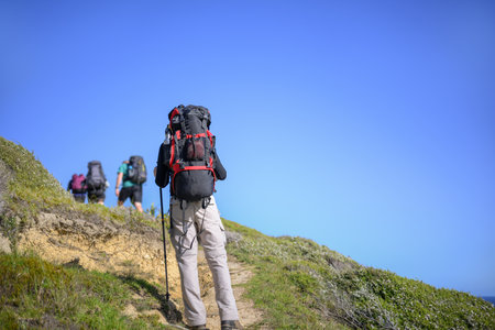 Backpacker hiking Cape Brett Walkway. Unrecognizable hikers in the distance. Bay of Islands.の写真素材