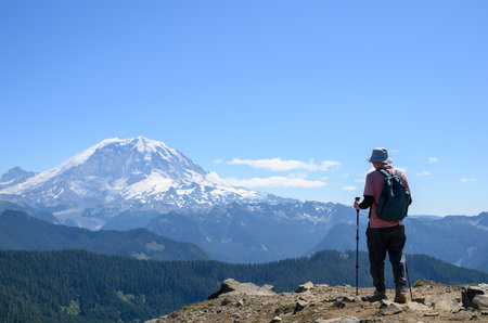 Man hiking Summit Lake trail. Mt Rainier in the distance. Mt Rainier National Park. Washington State.の写真素材