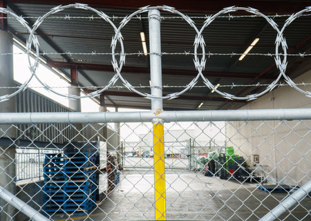 Razor and barbed wire topping a security fence of storage area. Auckland.の写真素材