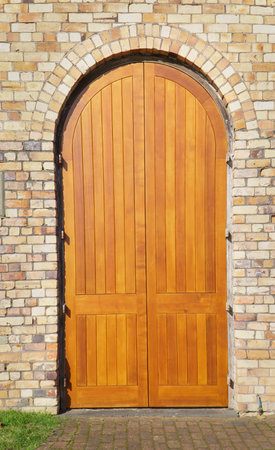 Arched double doors on a brick wall.の写真素材