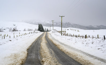 Tire tracks on a snow-covered slippery road. Ashburton Lakes. South Island.の写真素材