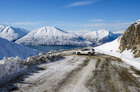 View of Ben Ohau Range and Lake Ohau. Car driving on winding mountain road. Twizel. South Island.の写真素材