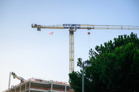 Construction cranes over a commercial building. American flag on a tower crane. California.