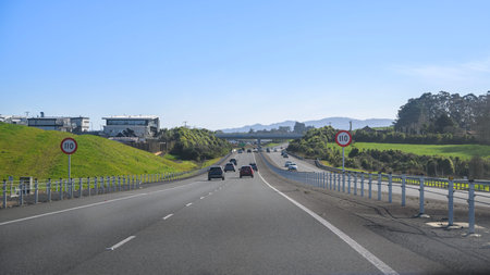 Traffic on Waikato Expressway. 110 kmh road speed signs by the side of motorway. New Zealand.