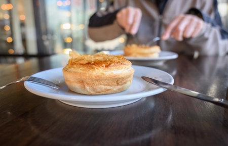 Steak and chess pie on a plate. Unrecognizable person eating pie in the restaurant.の写真素材