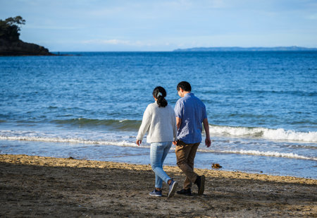 Couple holding hands and walking on the beach.の写真素材