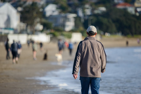 Man walking on the beach. Unrecognizable crowds of people enjoying the sunny day.の写真素材