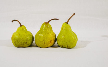 Three small pears on white cloth