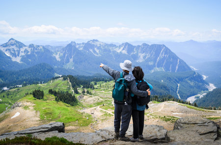 Man pointing to the distant view. Couple enjoying the view from Skyline Loop Trail. Mt Rainier...