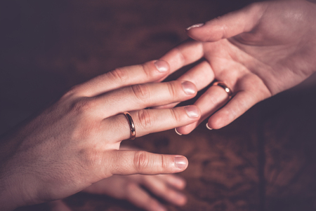 Wedding couple holding hands with rings on fingersの写真素材