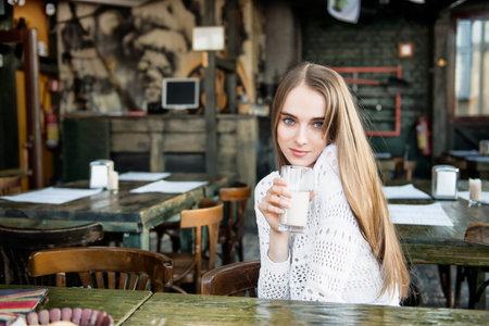 Beautiful happy woman drinking at the cafeの写真素材