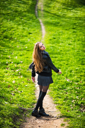 Beautiful woman walking on the footpath outdoorgの写真素材