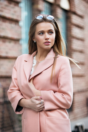 Beautiful fashionable young woman wearing pink stylish autumn jacketの写真素材