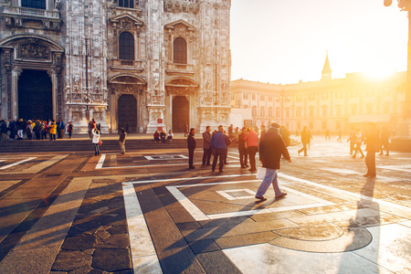 crowd of tourist people walking in center of old town near Duomo in Milan, Italy at sunset timeの写真素材