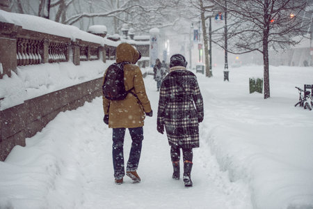 People walking on New York City Manhattan street during strong snow storm blizzard and cold weather.の写真素材