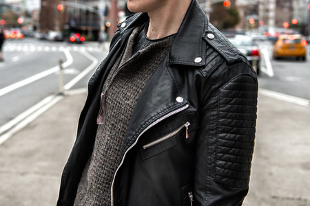 Men`s fashion concept. Stylish man wearing black leather jacket and walking on city streetの写真素材