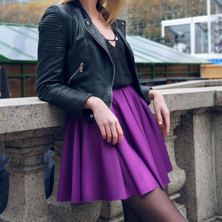Female scater skirt and leather jacket. Girl wearing sexy fashionable outfit with black leather jacket and purple circle skirt. Model girl in fashion skirt.の写真素材