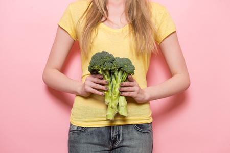 Weight loss vegetarian diet for women concept. Woman holding broccoli.の写真素材