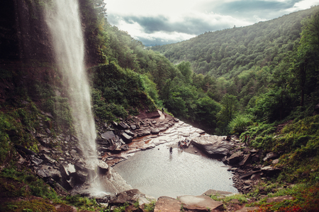 Scenic view on mountain waterfall and cave in forest with tourist people. Kaaterskill Falls and Clove.
の写真素材