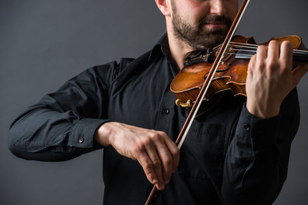 Musician man playing the violin. Musical instrument on performer hands. Classic music concept.