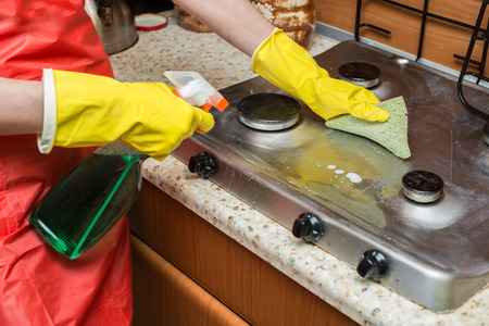 Woman cleaning the stove in the kitchen. Housekeeping concept.の写真素材