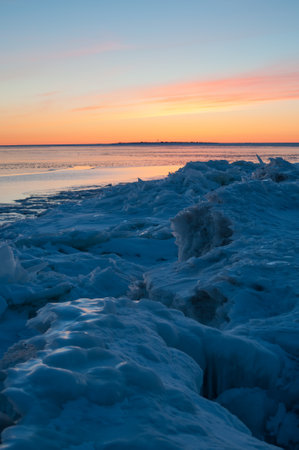Icy sea after deep winter sunset with drift ice piling on the shore of the Baltic sea in Reposaari, Finlandの写真素材