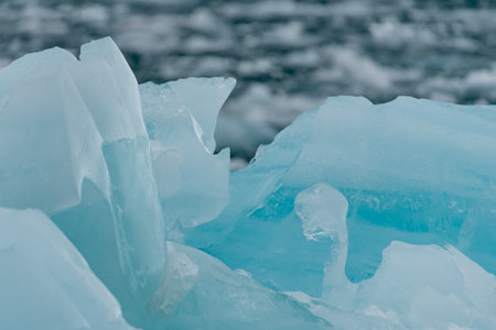 Close up of blue glacial ice floating in the sea in Svalbardの写真素材