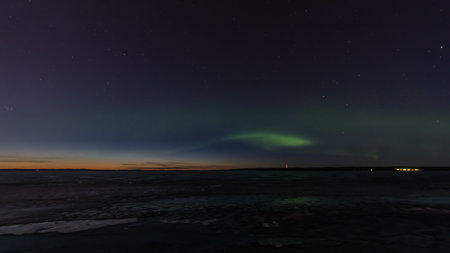 Green aurora borealis over a frozen lake in Tampere, Finlandの写真素材