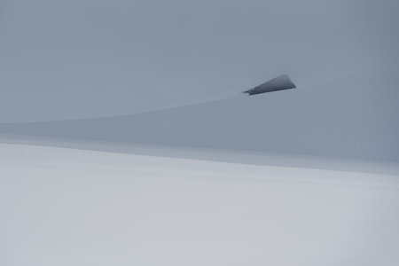 Approaching storm clouds creating a dramatic contrast on snow covered mountain in arctic Svalbardの写真素材