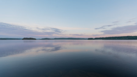 Summer lake scenery with clouds reflected on the water in Finlandの写真素材