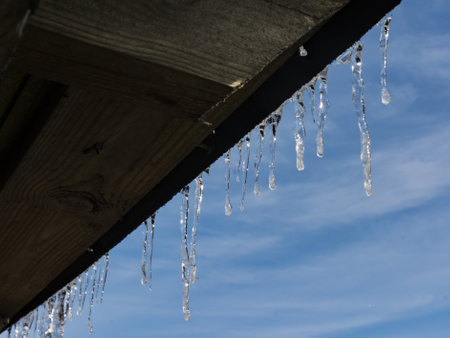 Icicles hanging from a wooden roof in spring winter in Finlandの写真素材