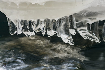 Ice formations over flowing waters of a stream in spring time in Finlandの写真素材