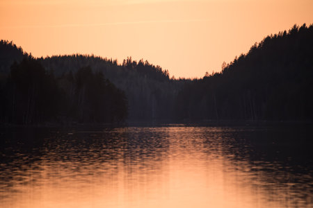 Lake scenery around sunset on a late spring evening in conifer forests of Finlandの写真素材
