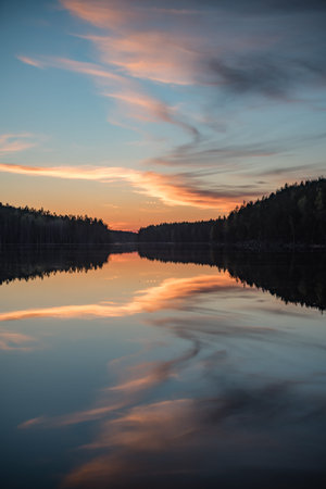 Lake scenery around sunset on a late spring evening in conifer forests of Finlandの写真素材