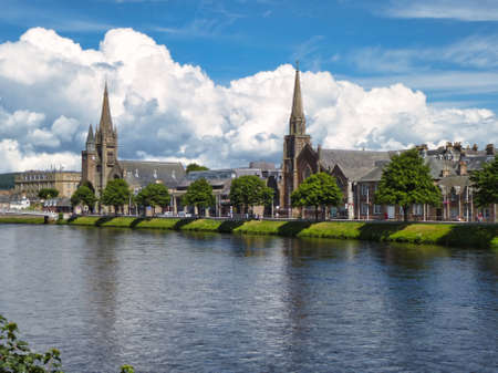 View along the bank of the River Ness with St. Columba High Church and Free North Church in Inverness, Scotland.の写真素材