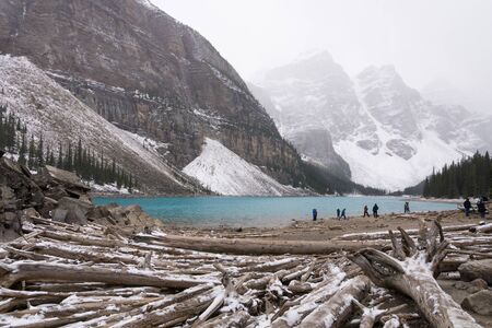 view over the shore of the blue moraine lake covered with snow in banff national park, Canadaの写真素材