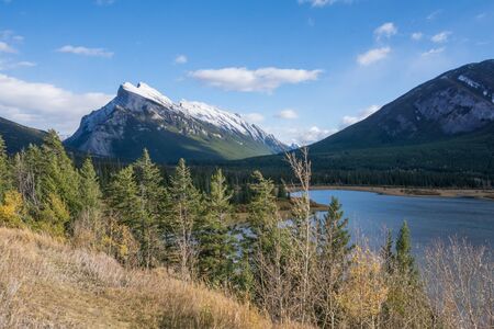mountain range, forest and river in the sun at banff national park canadaの写真素材