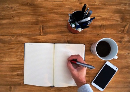 Home office phone call taking notes with coffeeの写真素材