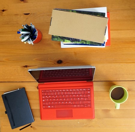home office wooden table computer notebook coffee and booksの写真素材