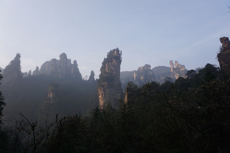 Mountains in China with trees and dust in sunshineの写真素材