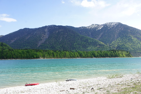 Very blue lake in the mountains of Bavaria in Germany with forrestの写真素材