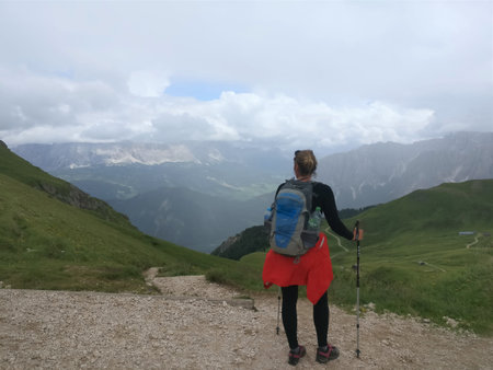 Girl with a big backpack hiking on a path in the mountainsのeditorial素材