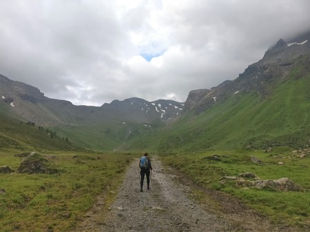 hiker girl walking on a long path in the mountains in the cloudy skyのeditorial素材