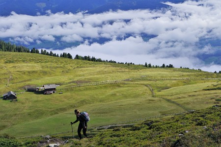 Hiker on a green meadow in the mountains with a hut hikingのeditorial素材