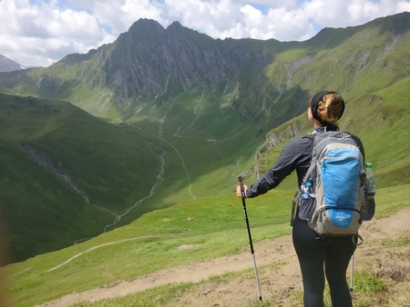 Hiking girl enjoying the view on a green meadow looking backのeditorial素材