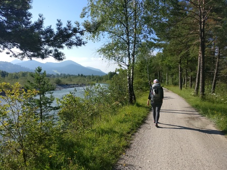 Girl hiker walking along a river with her backpackのeditorial素材