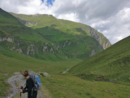 Hiking girl enjoying the view on a green meadow looking backのeditorial素材