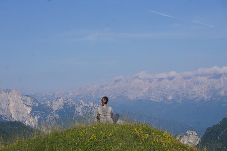 girl sitting on a mountain edge enjoying the viewのeditorial素材