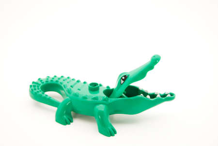Little green plastic crocodile with its mouth wide openの写真素材