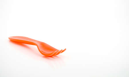 Orange childrens fork close-up,isolated against a white backgroundの写真素材